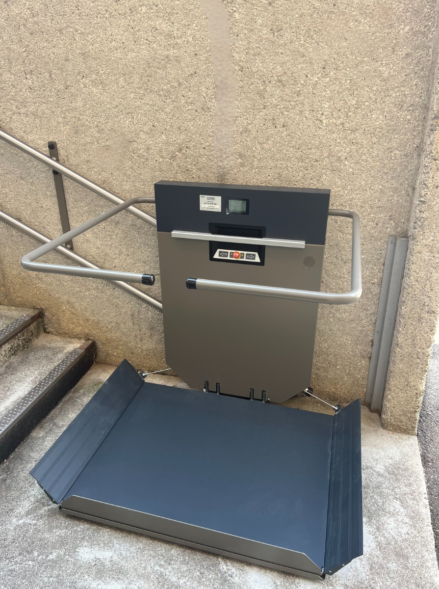 Installation d'une plateforme inclinée grise de chez GANSER à la cartoucherie de Bourg-lès-Valence par COPAS Accessibilité, spécialiste des équipements PMR, intervient en Drôme, Ardèche, Rhône, Isère, Vaucluse et Gard.